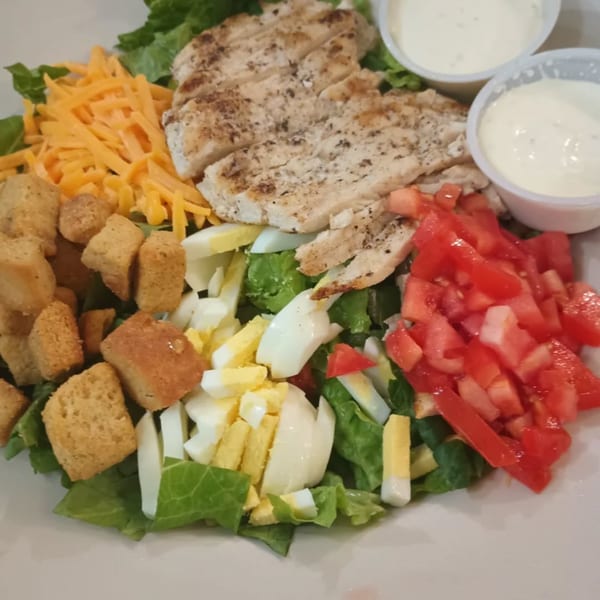 A Southern Taste Cafe grilled chicken salad with cheese, croutons, tomatoes, and hard-boiled eggs.